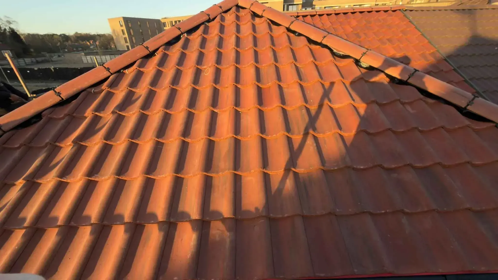 Re-tiled roof with a dry ridge system in Wokingham, Berkshire, photographed in low evening sunlight