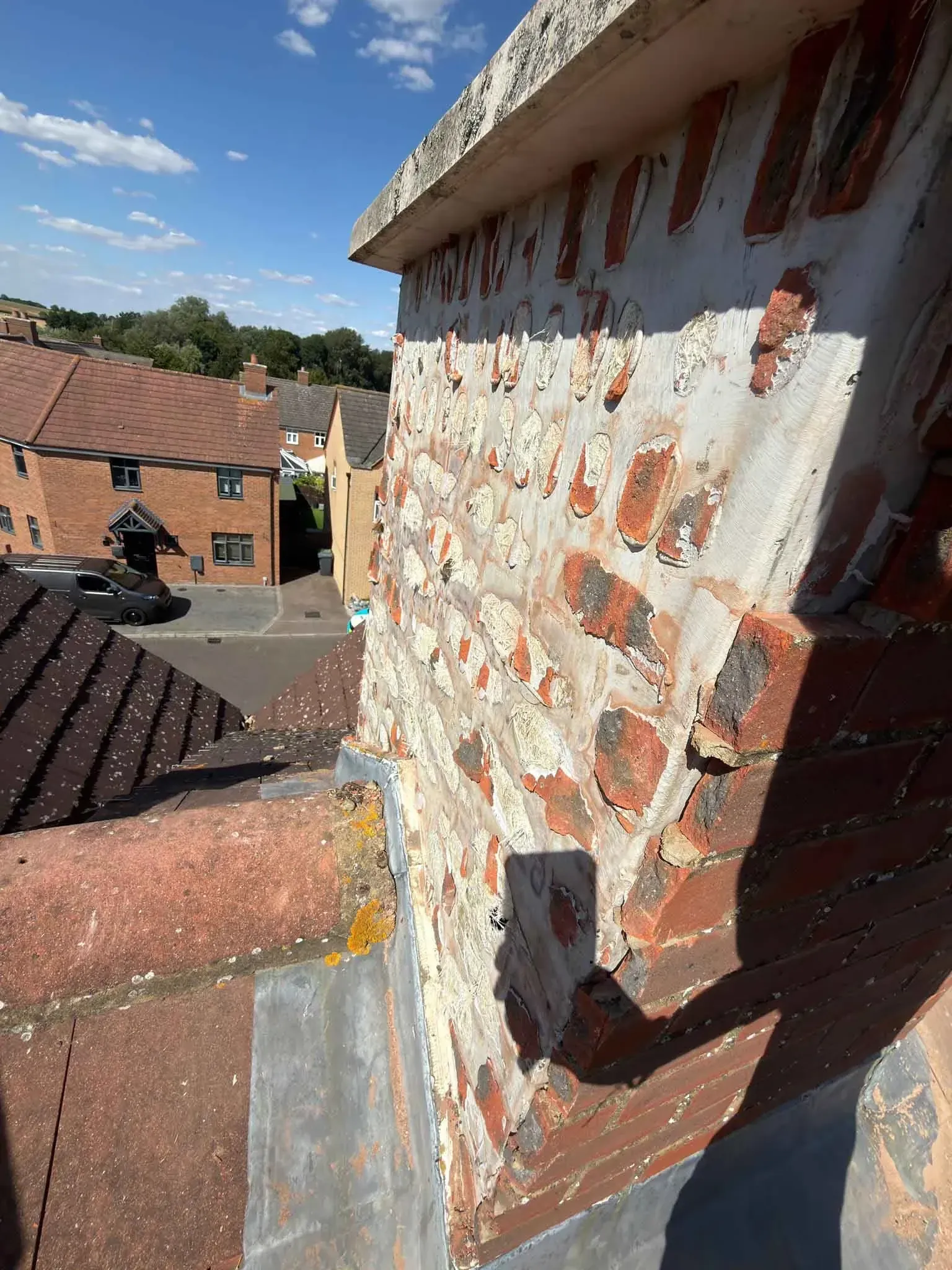 Side of an artificial chimney on a tiled roof in Ascot, Berkshire, with lead flashing at its base