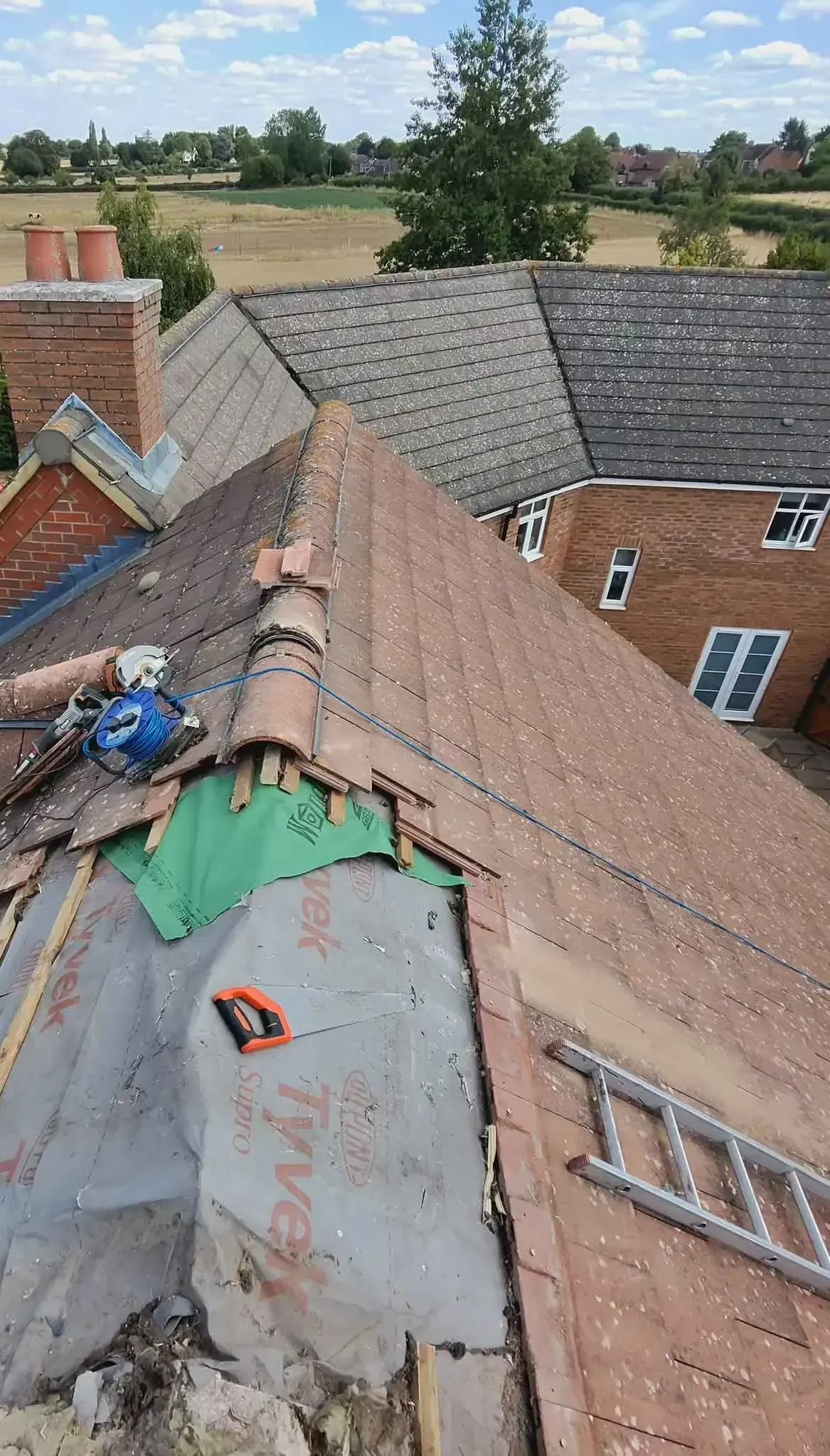 Roofing membrane and battens fitted across an opened section of roof in Ascot, Berkshire, with tiles removed alongside
