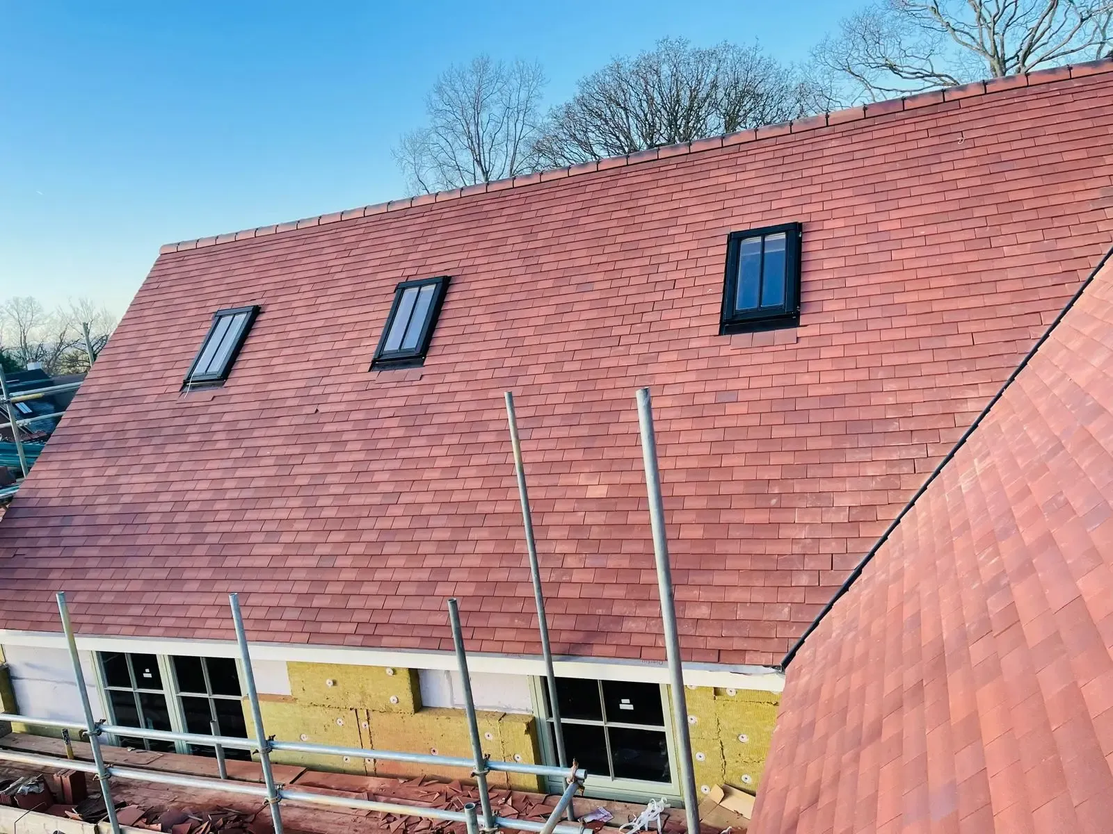A tiled pitched roof with three roof windows