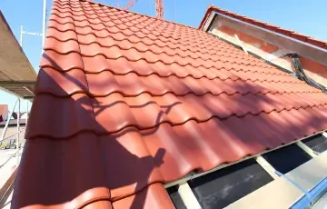 A newly tiled roof slope with a dormer window under construction